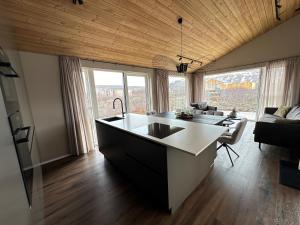 a kitchen with a sink and a living room at Holiday Home in Húsafell