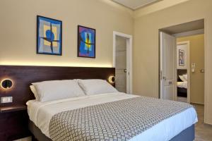 a bedroom with a bed and two paintings on the wall at Palm Suites in Naples