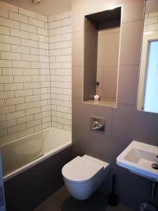 bagno con servizi igienici bianchi e lavandino di Home in Blackrock Dublin a Dublino