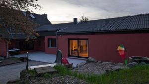 ein rotes Haus mit einem Fenster und einem Hof in der Unterkunft FeWo Sonnenschein Bungalow in Sankt Ingbert