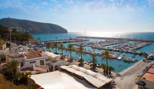 a view of a pool with palm trees and the ocean at Bungalow Aloha Moraira by Sun & Sea Homes in Moraira