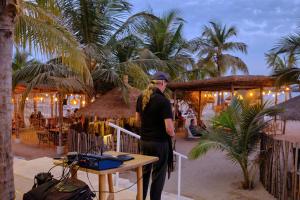 a man standing in front of a table on the beach at Hotel Royam in Saly Portudal