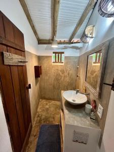 a bathroom with a sink and a mirror at Casa Aratu - Caraíva in Caraíva