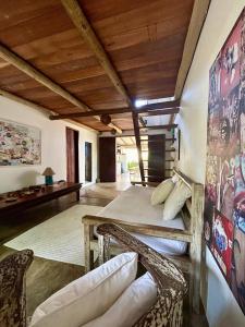 a bedroom with a bed and chairs in a room at Casa Aratu - Caraíva in Caraíva