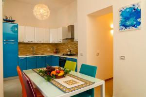 una cucina con armadi blu e un tavolo con un cesto di frutta di Casa Relax Mondello a Mondello