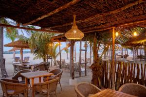 ein Restaurant am Strand mit Tischen und Stühlen in der Unterkunft Hotel Royam in Saly Portudal