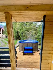 una casa de madera con vistas panorámicas a una bañera de hidromasaje en U Yaroslava Hotel, en Yaremche