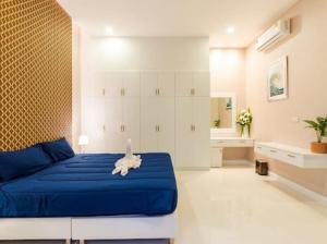 a bedroom with a blue bed and a bathroom at Fin Camping & Pool Villa in Ban Hup Kaphong