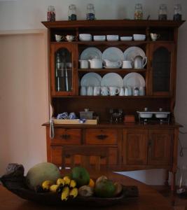 a wooden hutch with plates and a bowl of fruit at The Fever Tree Guest House in Hluhluwe +19 photos