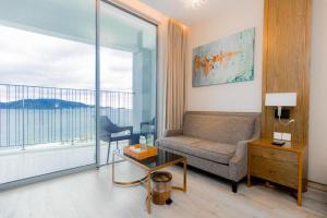 uma sala de estar com um sofá e uma grande janela em Best View Panorama Suites managed by MLB em Nha Trang