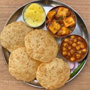 um prato de alimentos com biscoitos, grão-de-bico e molho em The Price Hotels Main Bazar Pahar Ganj New Delhi em Nova Deli