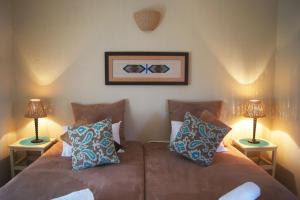 una camera con due letti e due lampade di The Fever Tree Guest House a Hluhluwe