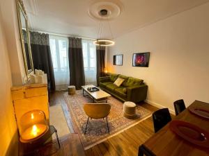 a living room with a green couch and a table at Maison Verdun Centre "L'Aparté" - Terrasse - Wifi - 8 personnes - Géré Par PrestaZen'Services in Verdun