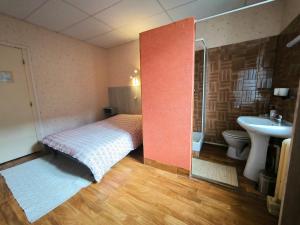 een kleine slaapkamer met een bed en een wastafel bij La Maison TILIA in Bessèges