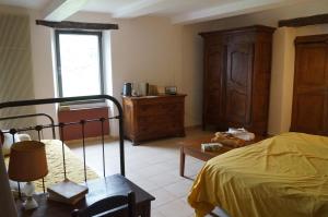 ein Schlafzimmer mit einem Bett, einer Kommode und einem Fenster in der Unterkunft Chambre d'Hôte dans MAS proche Anduze Cévennes avec piscine in Mialet