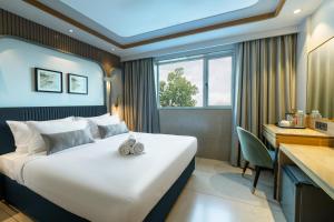 una camera d'albergo con un grande letto e una scrivania di Ajanta Continental-Mumbai Airport a Mumbai