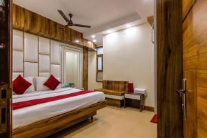 um quarto com uma cama e um banco num quarto em The Price Hotels Main Bazar Pahar Ganj New Delhi em Nova Deli