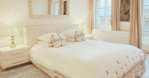 ポラントリュイにあるアジュワスパの白いベッドルーム(白いベッド1台、鏡付)