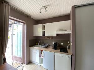 een kleine keuken met witte kasten en een raam bij Le Chalet de Malo in Biscarrosse