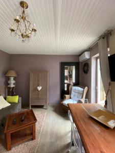 een woonkamer met een tafel en een bank bij Le Chalet de Malo in Biscarrosse
