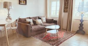 a living room with a brown couch and a table at AjoieSpa in Porrentruy