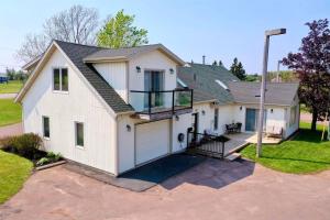 a large white house with a garage at Light House Apartment in Brackley Beach