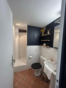 a bathroom with a toilet and a tub and a sink at Domaine Malar in Guillerval