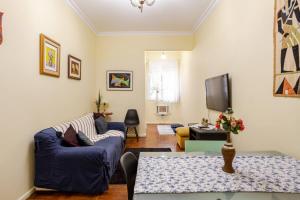sala de estar con sofá azul y TV en Apartamento Premium, en Río de Janeiro