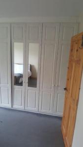 rząd białych szafek w pokoju z drzwiami w obiekcie 4 Bed Detached House in Drogheda w mieście Drogheda