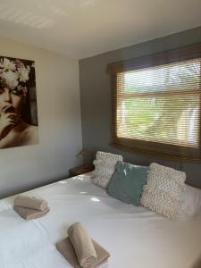 a bedroom with a large white bed with a window at Casa di Caribe - Deluxe beach house in Willemstad