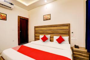 ein Schlafzimmer mit einem großen Bett mit roten Kissen in der Unterkunft OYO Flagship Hotel Sangam Palace in Bamrauli