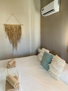 een wit bed met handdoeken en airconditioning bij Casa di Caribe - Deluxe beach house in Willemstad