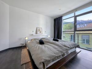- une chambre avec un grand lit et une grande fenêtre dans l'établissement Dolce Vita close to 4 Vallées - Swiss Alps, à Martigny-Ville