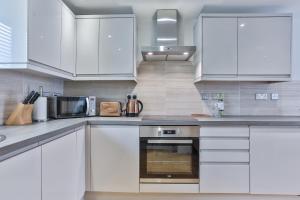 uma cozinha com armários brancos e um micro-ondas em 1BR Gem in Great Location em Sheffield