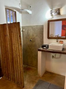 a bathroom with a sink and a mirror at Casa Aratu - Caraíva in Caraíva