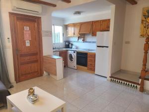 uma cozinha com armários de madeira e um frigorífico branco em Casa del Sol in Els Poblets em Els Poblets
