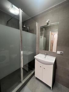 a bathroom with a sink and a shower and a mirror at Heart of Old Town / Floriańska 19 in Krakow