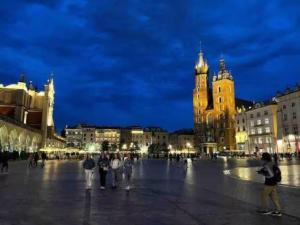 a group of people standing in a square at night at Heart of Old Town / Floriańska 19 in Krakow