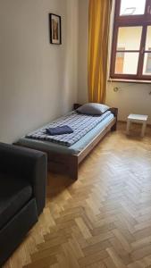 a bedroom with a bed and a couch and a window at Heart of Old Town / Floriańska 19 in Krakow
