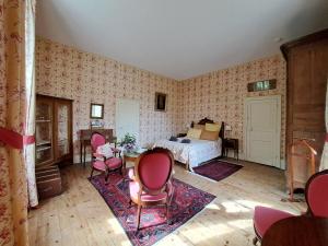 a bedroom with a bed and a table and chairs at Le manoir d'Estiveaux in Le Châtelet
