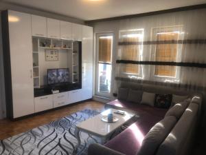 a living room with a couch and a table at Orion apartment in Pristina