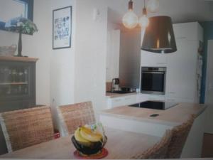 eine Küche mit einem Tisch und einer Schale Bananen drauf in der Unterkunft Appartement Montreuil 60M2 - Idéal JO Paris 2024 in Montreuil