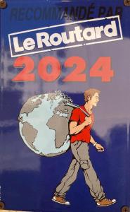 um cartaz de um homem carregando um globo em Hôtel Porte de Camargue - Les Quais d'Arles em Arles