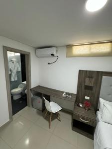 Schlafzimmer mit einem Bett, einem Schreibtisch und einem WC in der Unterkunft Hotel Juan Pablo 2 in Ríohacha