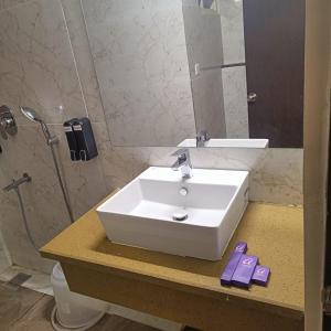 a bathroom with a white sink and a mirror at ASTRA HOTELS & SUITES WHITEFIELD NEAR TO NALLURAHALLI METRO STATION and KTPO in Bangalore