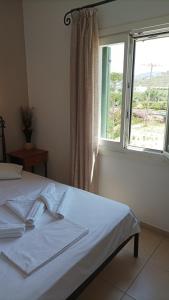 a bedroom with a white bed with a window at Magic Land in Plaka