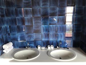 ein Badezimmer mit 2 Waschbecken und blau gefliesten Wänden in der Unterkunft Seeblick und offener Kamin - Casa di Florian in Tremosine sul Garda
