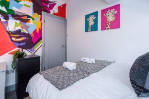 een slaapkamer met een bed en een schilderij aan de muur bij LFC Themed Apartment Anfield in Liverpool