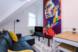 een woonkamer met een bank en een schilderij aan de muur bij LFC Themed Apartment Anfield in Liverpool
