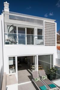 una vista exterior de una casa blanca con sillas en Casa Nova en Silves